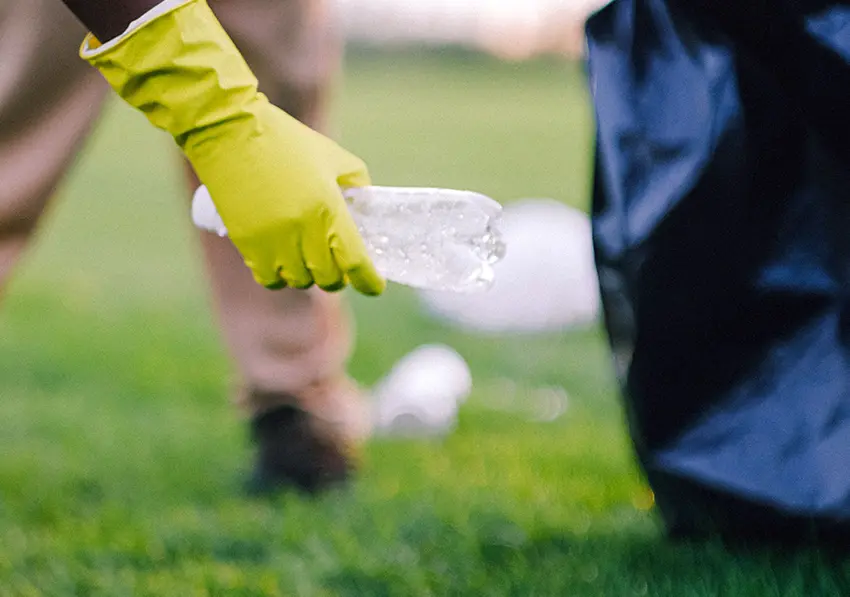 Hand picking up plastic bottle